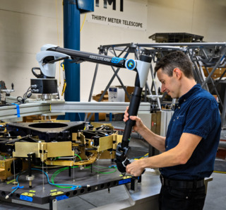 TMT Opto-Mechanical Engineer Alastair Heptonstall inspecitng an assembly at the TMT technical lab in Monrovia.